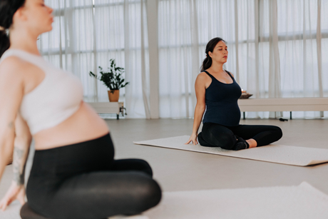 Twee zwangere vrouwen in yoga houding